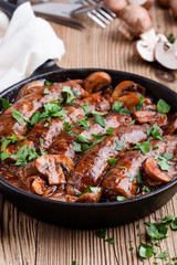 Sausages with onion and mushrooms gravy