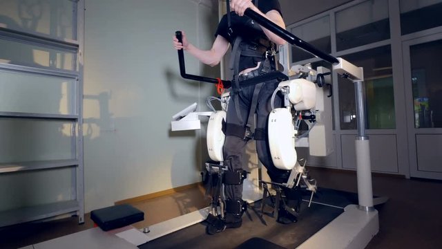 A man undergoes a rehabilitation session in an exoskeleton suit. 