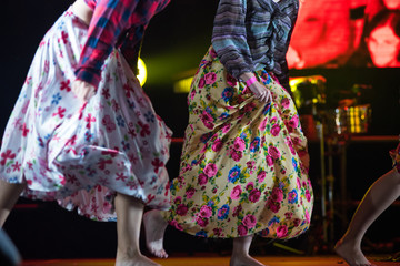 Young dancer woman barefoot in gypsy dress dancing on stage