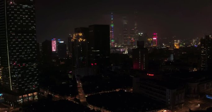 SHANGHAI, CHINA – JUNE 2016 : Aerial shot over Central Shanghai at night with view of Shanghai Tower, Oriental Pearl TV Tower, Jin Mao Tower and World Financial Center