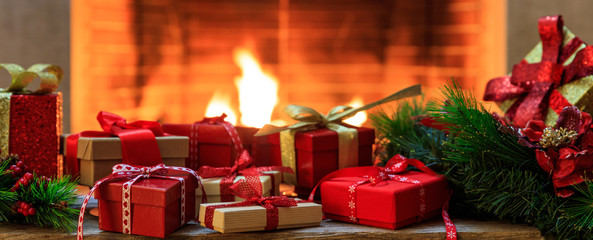 Christmas gifts on burning fireplace background