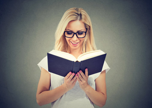 Portrait of beautiful woman wearing glasses reading a book 