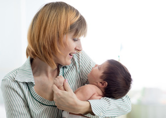 mom looking at infant baby in nursery