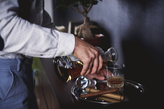 Unrecognizable Man Pouring A Glass Of Whiskey