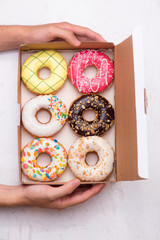 Colored donuts with glaze. Assorted doughnuts with different fillings in the box