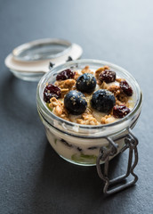 yoghurt with grapes, meusli crumble and cranberries in preserving jar