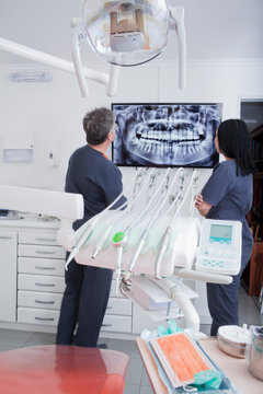 Dentist and dental nurse looking at scan