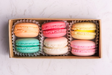 Set of different french cookies macaroons in a paper box. Top view.