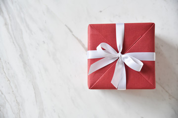 Top view of red gift box with white ribbon.