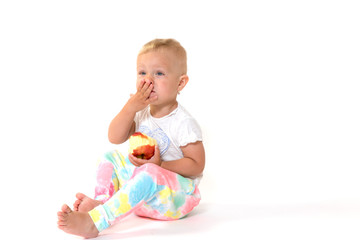 Cool toddler girl is holding a red apple