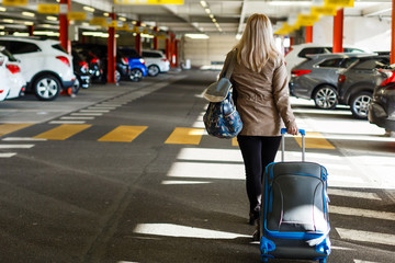 girl with bag in the parking at the airport
