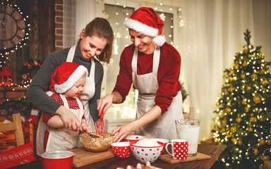 family mother father and baby bake christmas cookies.
