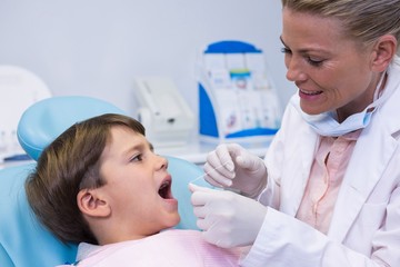 Dentist examining boy at medical clinic