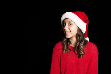 Excited young girl in red sweater and Santa's cap