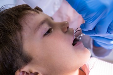 Doctor examining cute boy at clinic