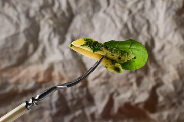 Pasta with green pesto close up on fork