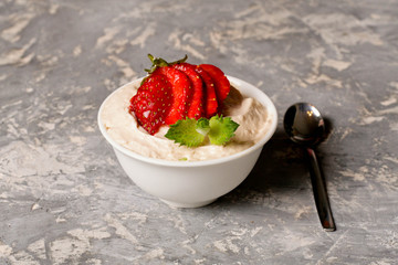 Cottage cheese with mint and strawberries in white bowl