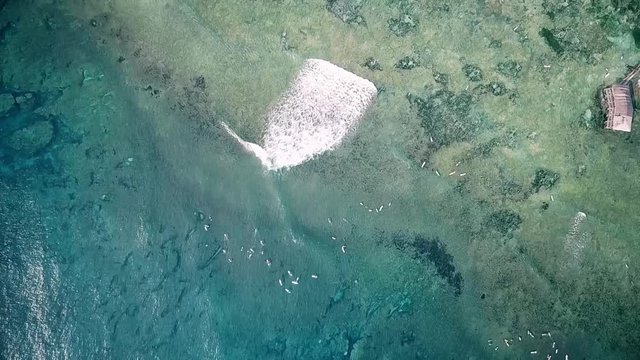 Aerial top view of waves breaking and surfers surfing