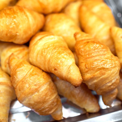 Fresh croissants in plate at supermarket store