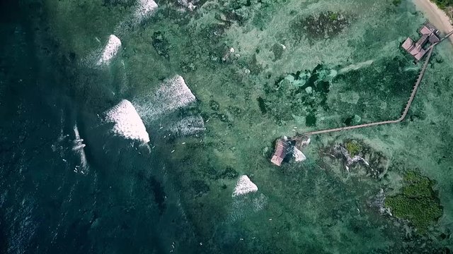 Aerial top view of waves breaking and surfers surfing