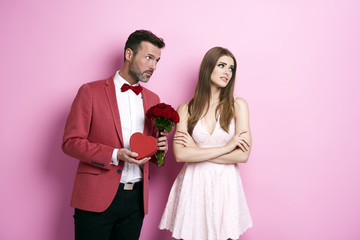 Man with bunch of rose and chocolate box apologizing fiancée
