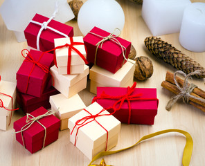 Stack of red and beige gift box and Christmas decoration on wooden background