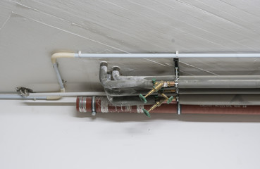 Isolierte Heizungsrohre an einer Betondecke eines Hauses