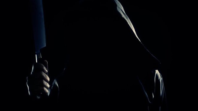 Waving nightmare: a faceless friar (a ghost, a ghoul or a madman) throwing an axe chopper in the air. Scary weird horror Halloween clip.
