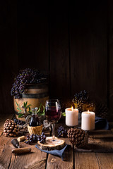 Red wine from a barrel with grapes and a glass of wine