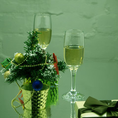 Two crystal glasses with soda on a black background with spruce branches. A stream of carbonated...
