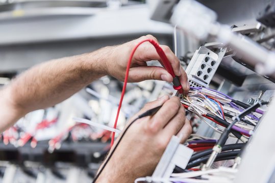 Close-up of man using voltmeter in factory