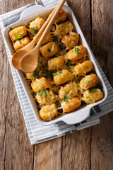 Baked Tater Tots with ground beef, corn and cheese close-up. Vertical top view © FomaA