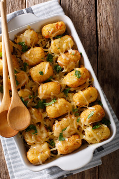 American Food: Tater Tots with cheese, meat, corn and parsley close-up. Vertical top view