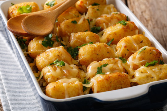Hot Baked Tater Tots with cheese, meat, corn and parsley close-up in on the table. horizontal