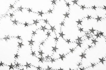 Christmas background with silver stars decorations on white. Simple Christmas composition with copy space