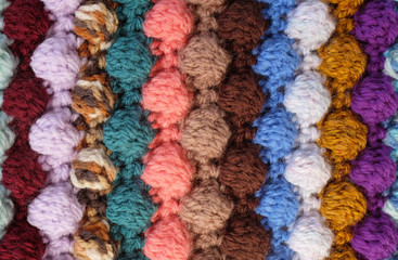 Vertical bobble crochet stitches, multi-coloured wool striped background