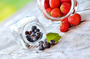 Glass jar with wild blueberries and strawberries