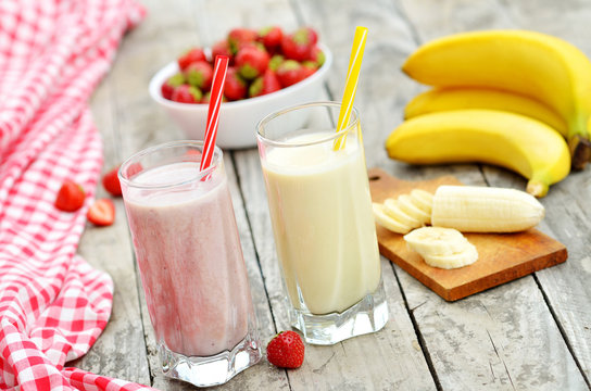 Strawberry and banana milkshake smoothie in the glass with straw