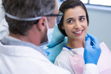 Patient smiling while receiving dental treatment at clinic