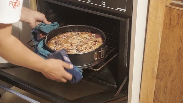 Women remove freshly baked French Quiche from oven.