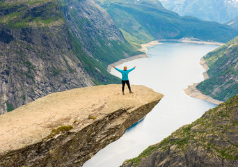 Sporty woman posing on Trolltunga Norway