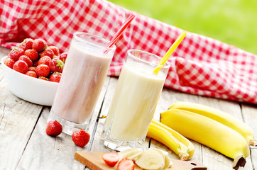 Banana and strawberry milkshake smoothie in the glass with straw