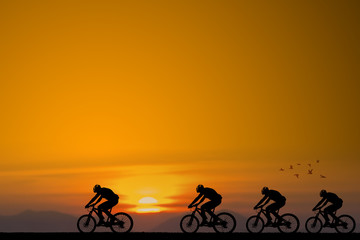 Fototapeta premium Silhouette of cyclist with friend on the background of beautiful sunset