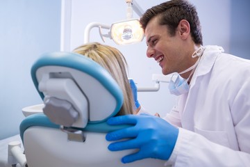 Dentist examining woman at clinic