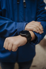 Smart watch on the boy's hand in blue jacket