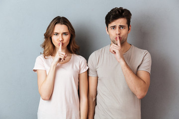 Portrait of a serious couple showing peace gesture