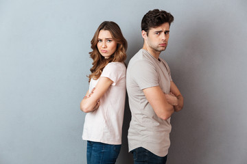 Portrait of an upset sad couple standing back to back