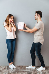 Full length portrait of a man giving a present box