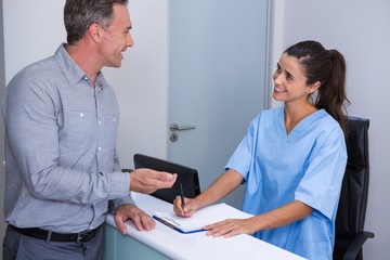 Smiling doctor and patient talking at desk