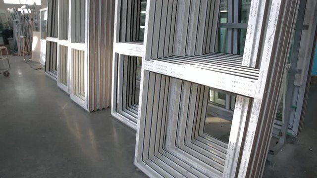 Plastic windows without double-glazed windows are in the assembly shop. Modern workshop for the production of plastic and metal windows and doors. Factory Work on production of PVC windows. Dolly up.
